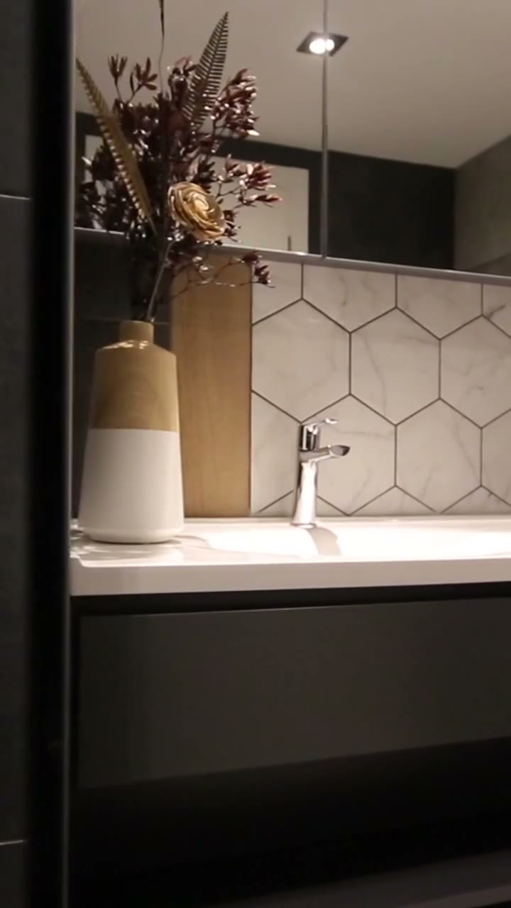 Moody, spa-like bathroom with dark finishes